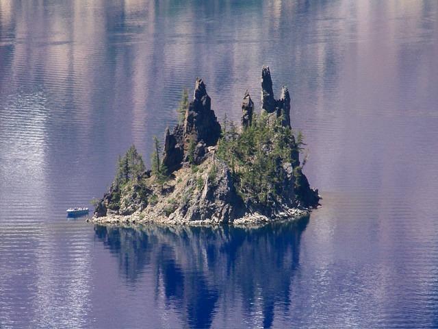 Close up f the island. The water looks purple because of reflections.