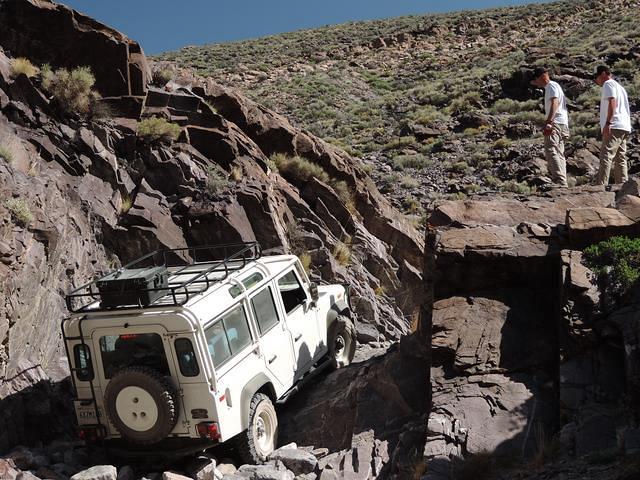 The land rover has to be winched up the waterfall.